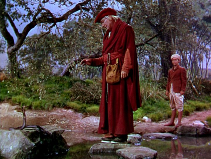 Fotograma de la versión cinematográfica de 1950. El lama (Paul Lukas) habla con alguien que se reencarnó en serpiente, ante la mirada de Kim.